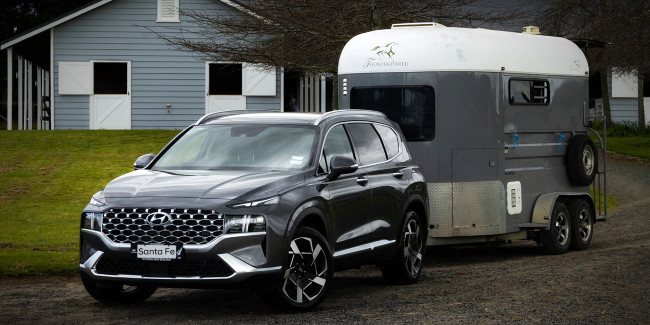 Best SUVs with High Towing Capacity in NZ - Pictured here a Hyundai Santa Fe SUV towing a horse float.